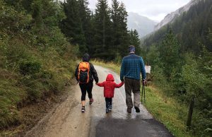 family walking on road in woods